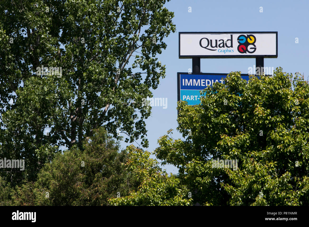 A logo sign outside of a facility occupied by Quad/Graphics in Lomira, Wisconsin, on June 24, 2018. Stock Photo