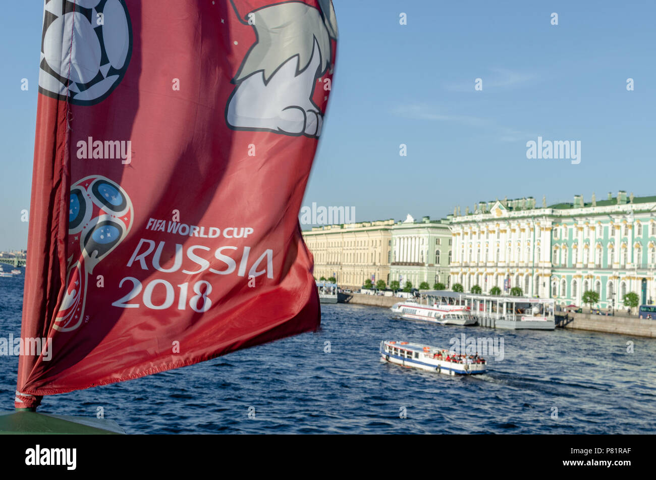 Flag with the official Russia 2018 world cup mascot and logo on the Neva river overlooking the Winter Palace in St Petersburg. Stock Photo