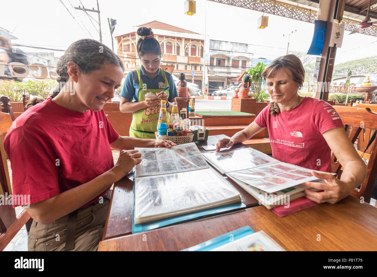 Tourists choosing food from a pictorial menu, Pakse, Laos Stock Photo