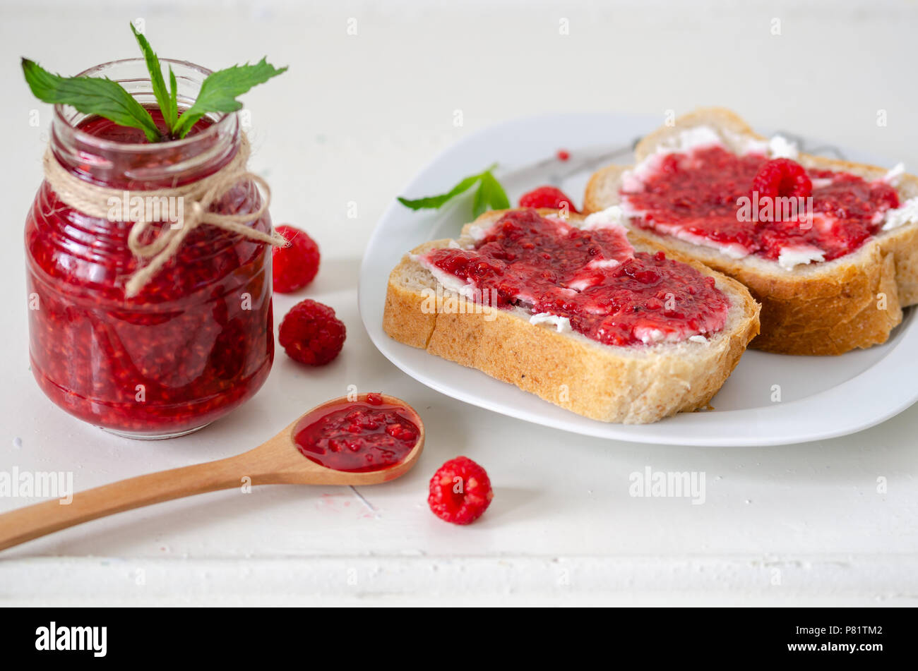 Raspberry jam on two slice of bread Stock Photo - Alamy