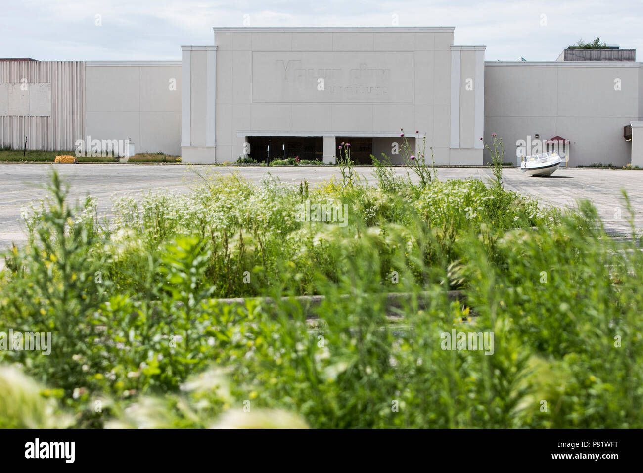 An abandoned boat is seen in a parking lot outside of the mostly abandoned Granville Station Mall in Milwaukee, Wisconsin on June 22, 2018. Stock Photo