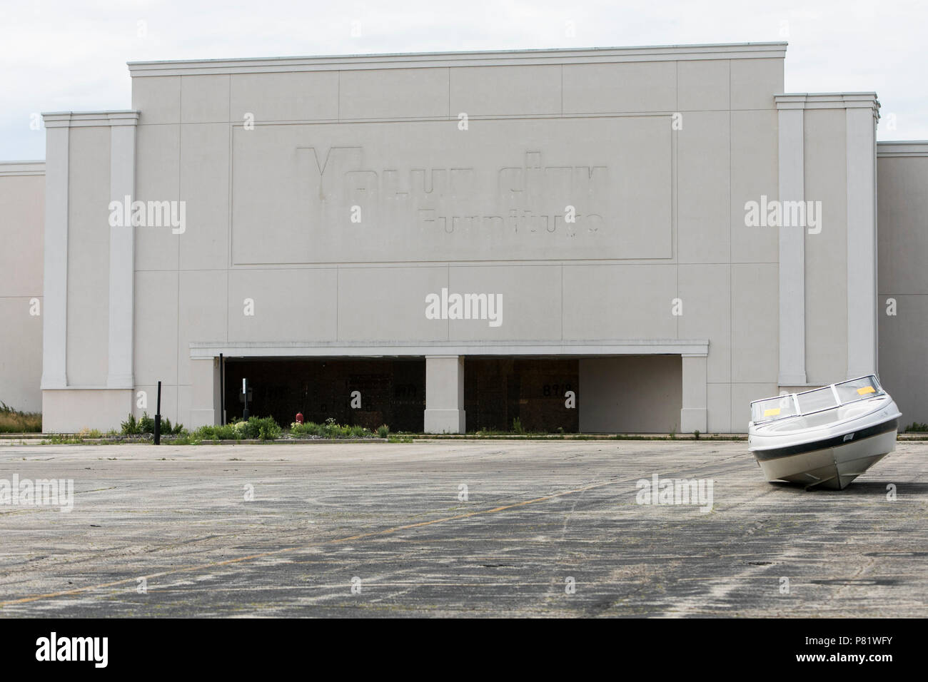 An abandoned boat is seen in a parking lot outside of the mostly abandoned Granville Station Mall in Milwaukee, Wisconsin on June 22, 2018. Stock Photo