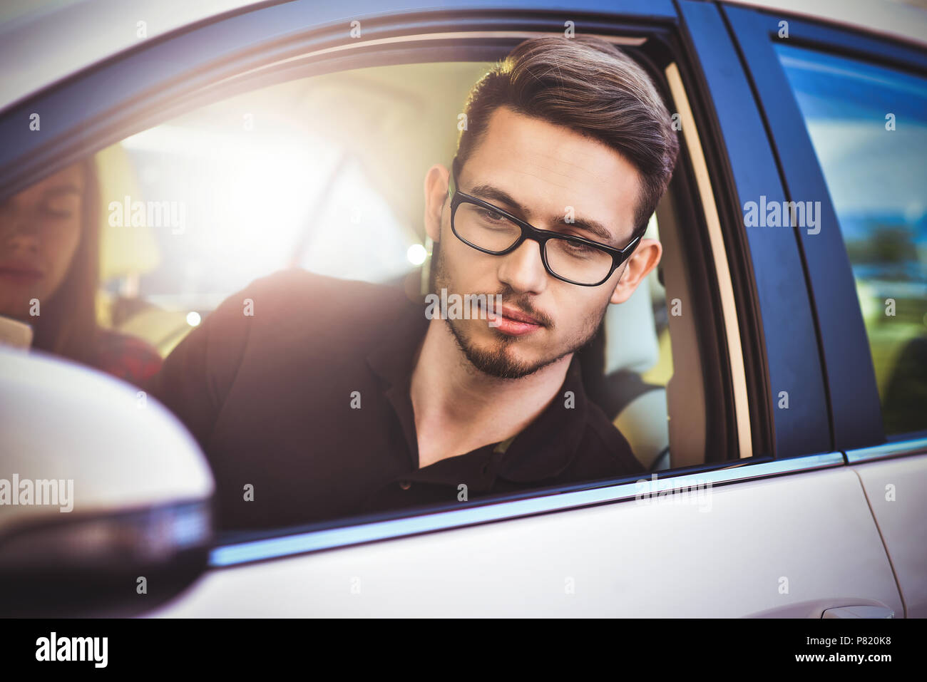 Enjoying travel. Beautiful young couple sitting on the front passenger seats and smiling while