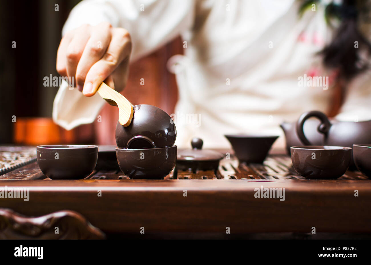 Chinese tea ceremony, woman cleaning teacup with boiled water Stock Photo