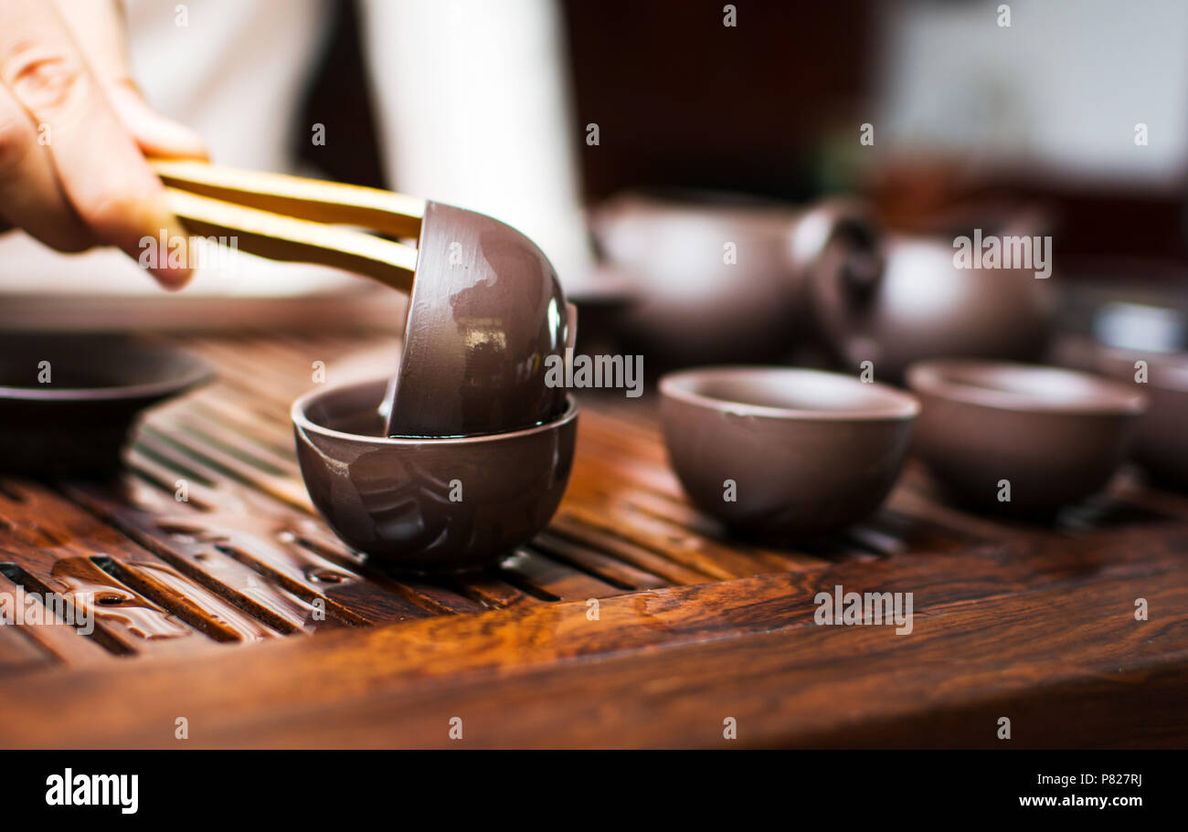 Chinese tea ceremony, woman cleaning teacup with boiled water Stock Photo