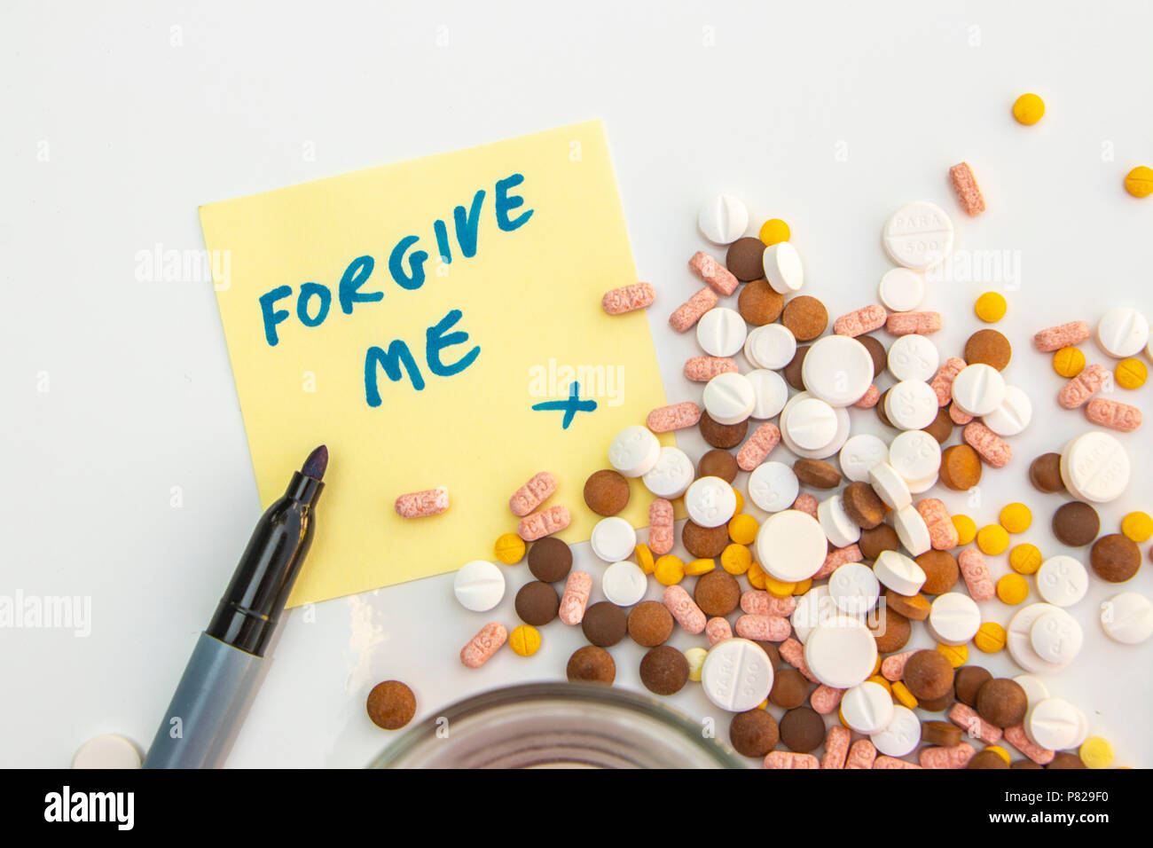 pills drugs and suicide note "forgive me" with apology. concept: loneliness depression suicide Stock Photo