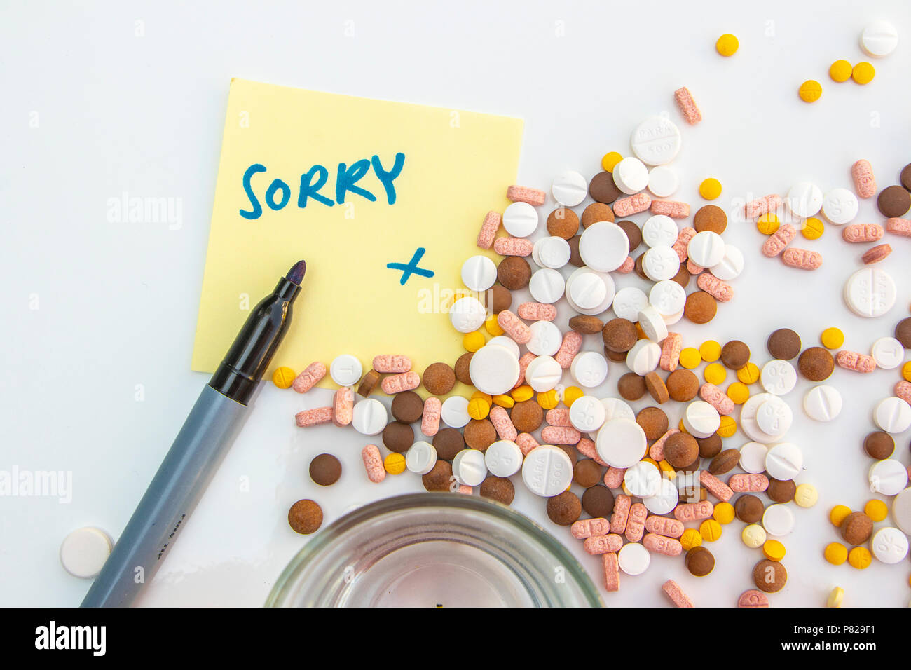pills drugs and suicide note "sorry" with apology. concept: loneliness depression suicide Stock Photo