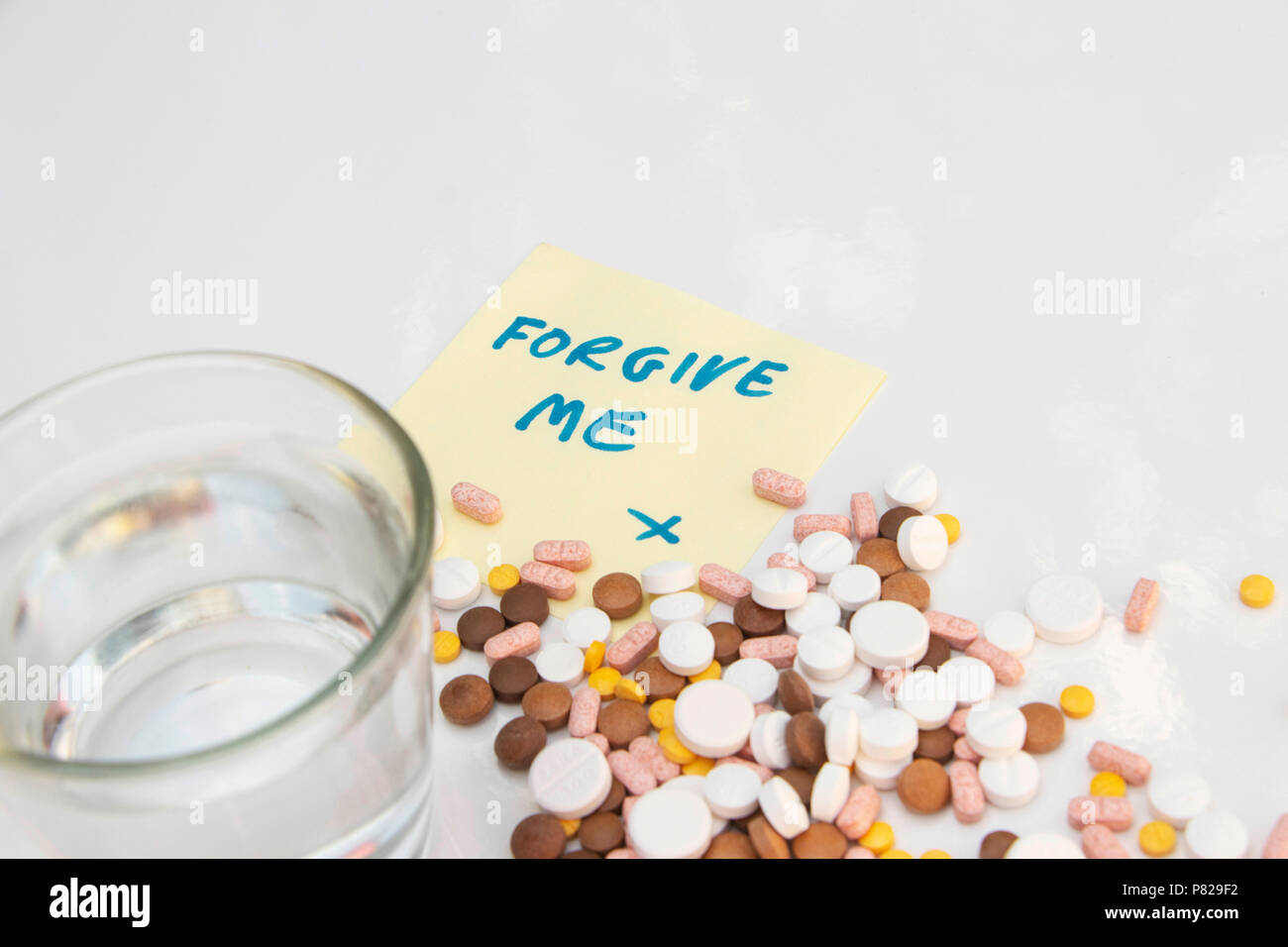 pills drugs and suicide note "forgive me" with apology. concept: loneliness depression suicide Stock Photo