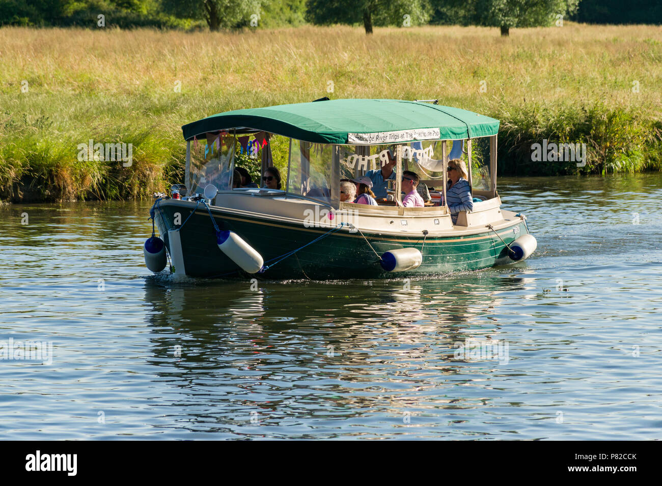 A group of people enjoying a cruise on a small river boat on the river Cam on a sunny Summer day, Cambridge, UK Stock Photo