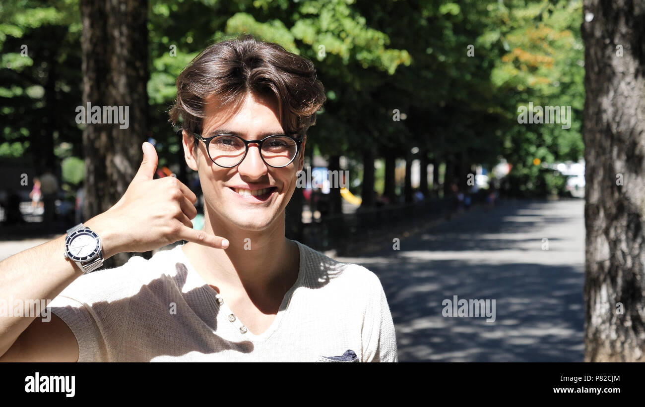 Young man doing call me sign with hand Stock Photo
