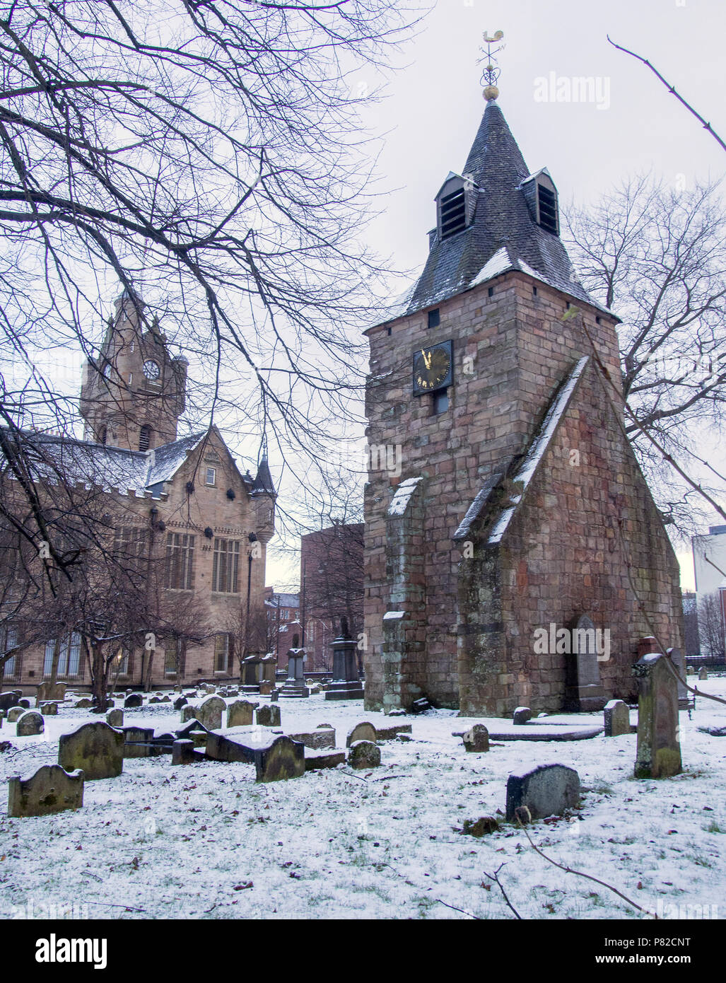 RUTHERGLEN, SCOTLAND - DECEMBER 29 2017: A side view of St. Mary’s steeple in the snow at the Old Parish Church graveyard. Stock Photo