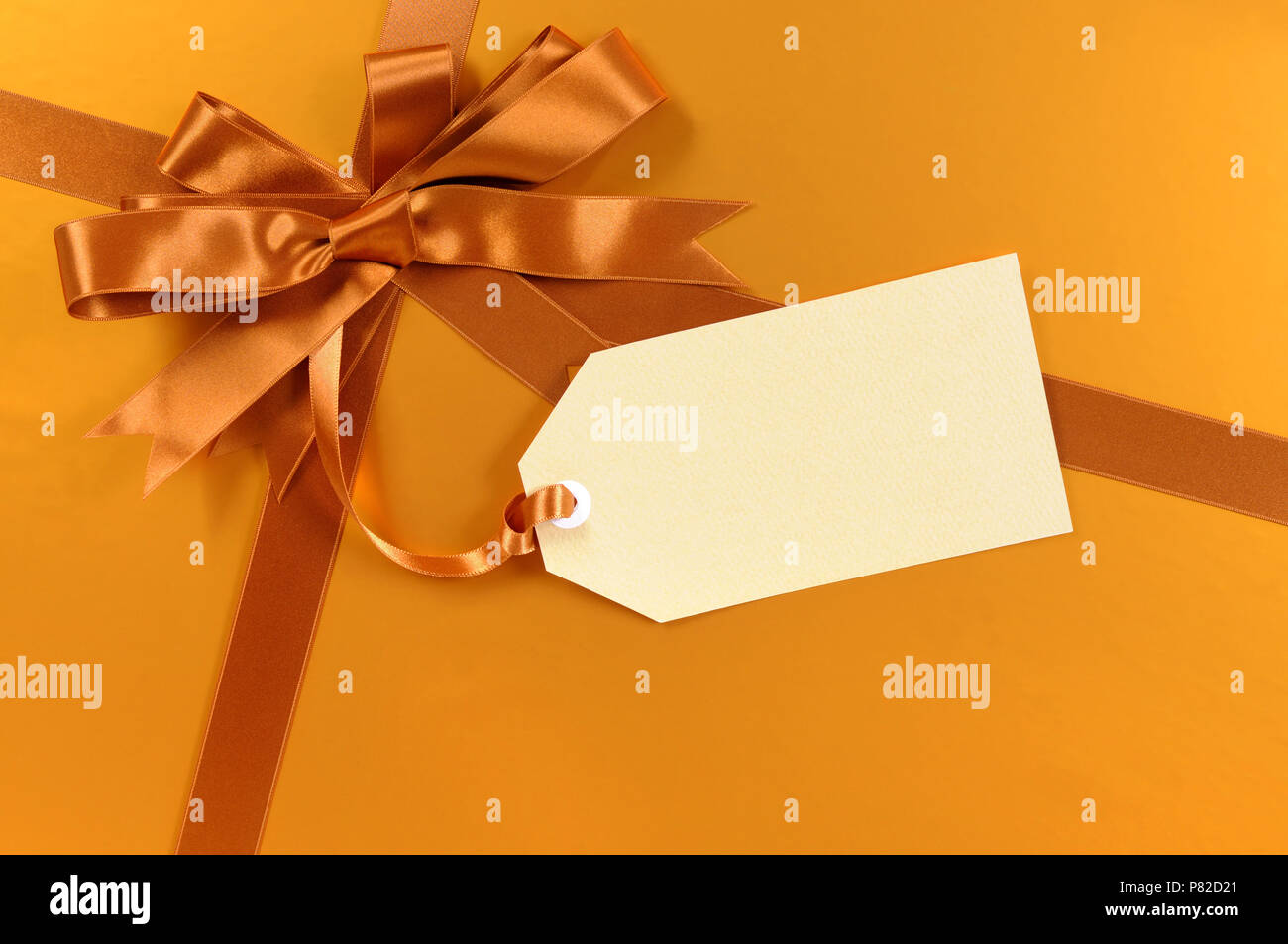 Gold christmas gift background ribbon and bow, gift tag Stock Photo - Alamy