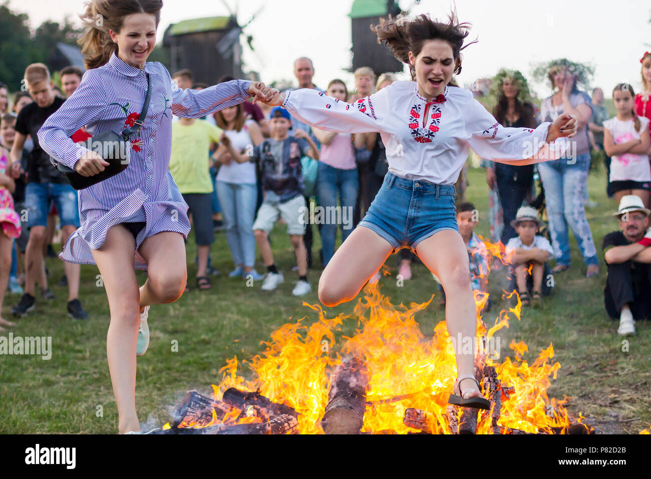 KYIV, UKRAINE - JULY 6, 2018: Young people jump over the flames of ...