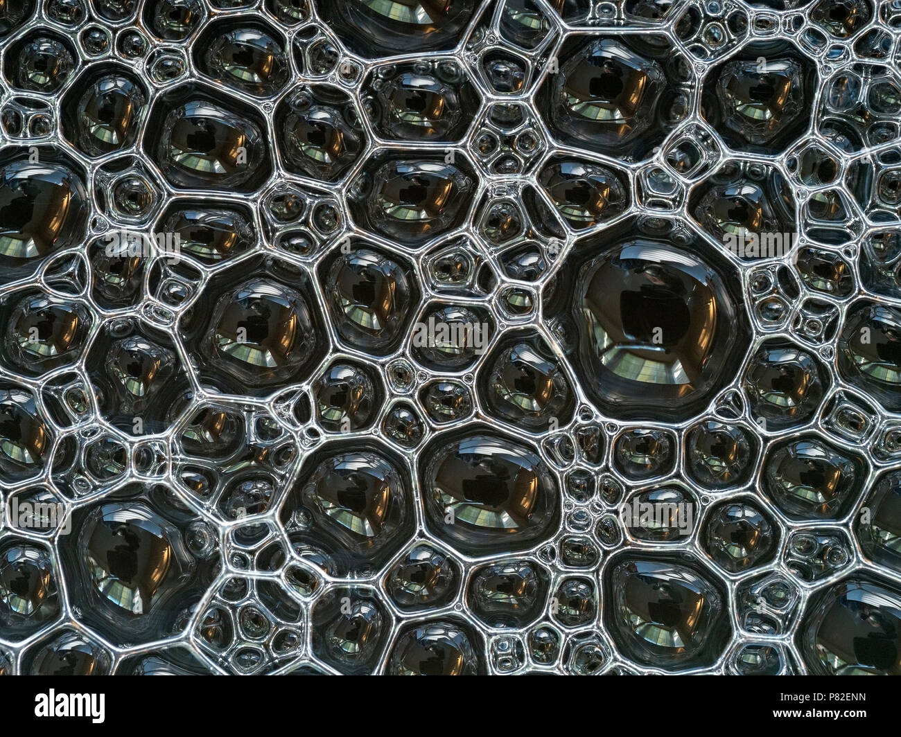 A closeup of a layer of lots of small soap bubbles floating on water Stock Photo