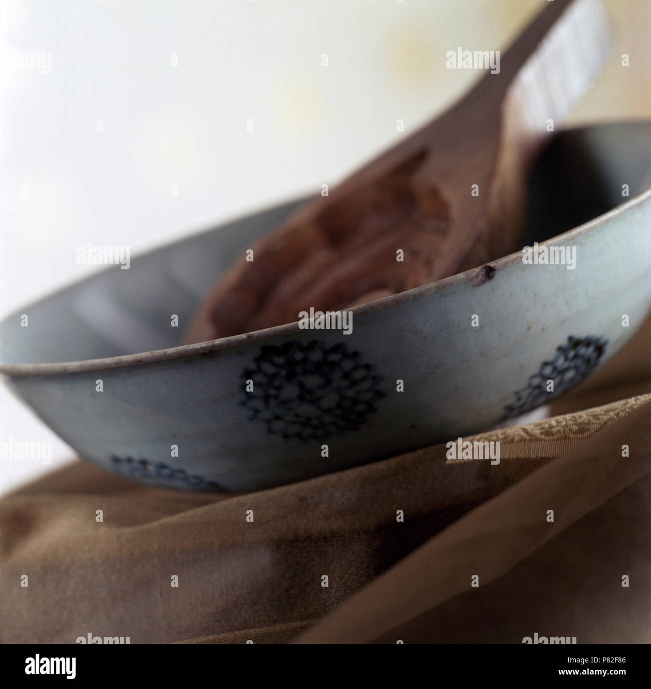 Close-up of a decorative pottery bowl with a rustic wooden spoon Stock Photo
