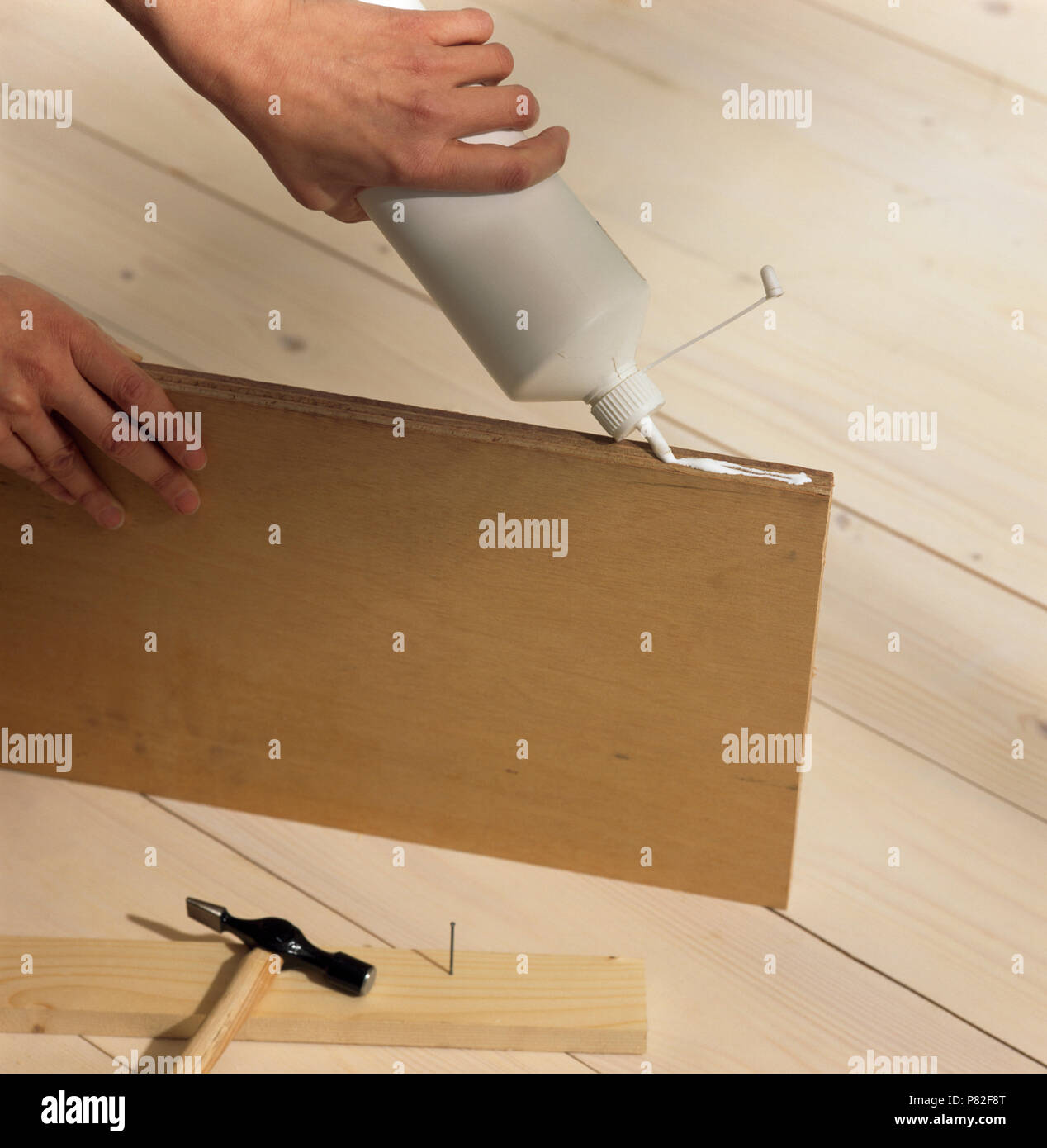 Closeup of hands applying glue to an MDF board Stock Photo Alamy