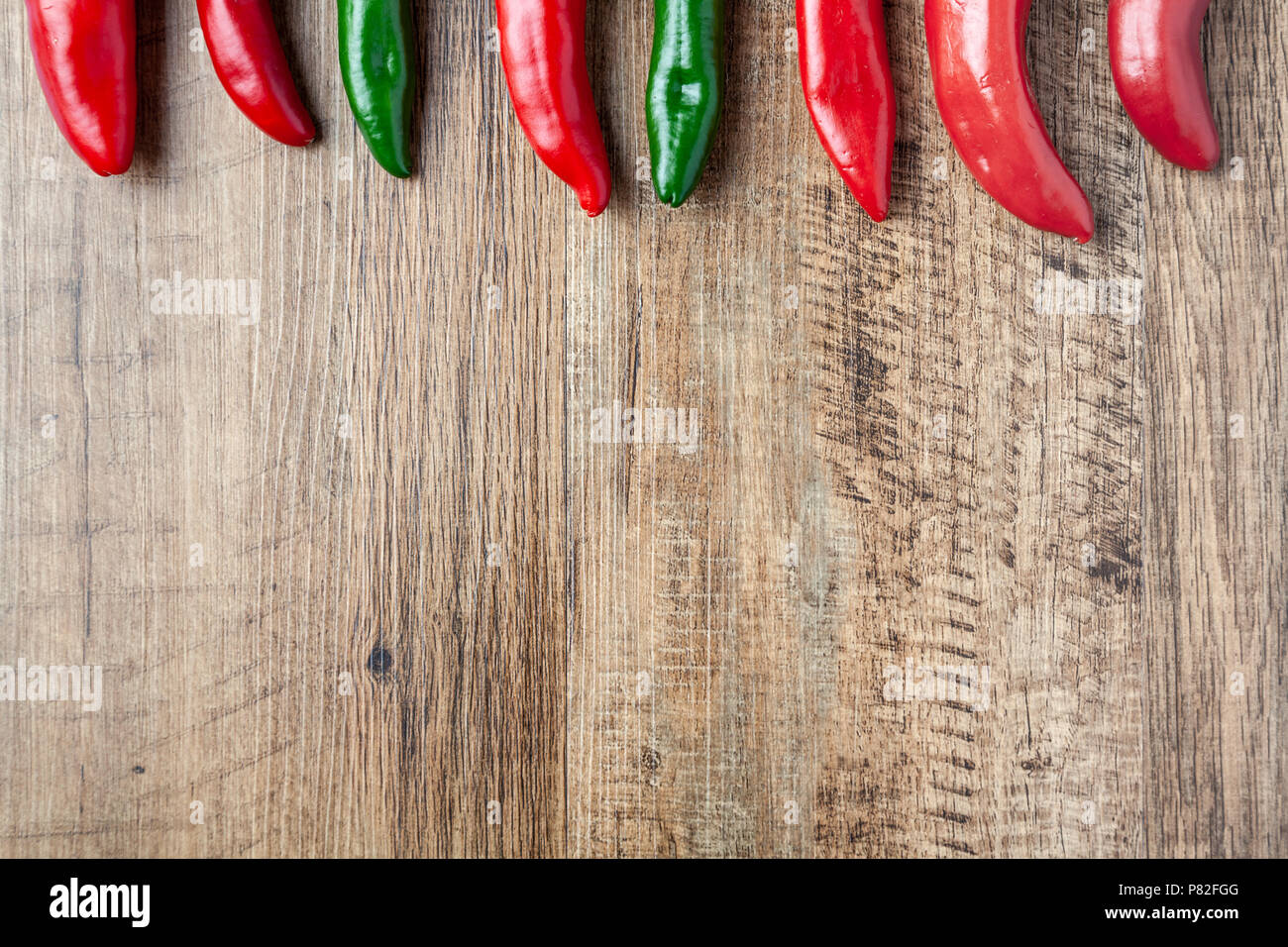 Red and green chilli pepper on wooden table with copy space Stock Photo ...