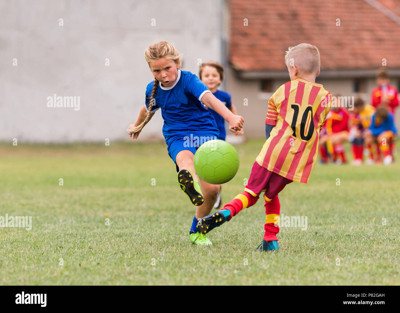 Kids soccer football young little girl is shooting ball at soccer