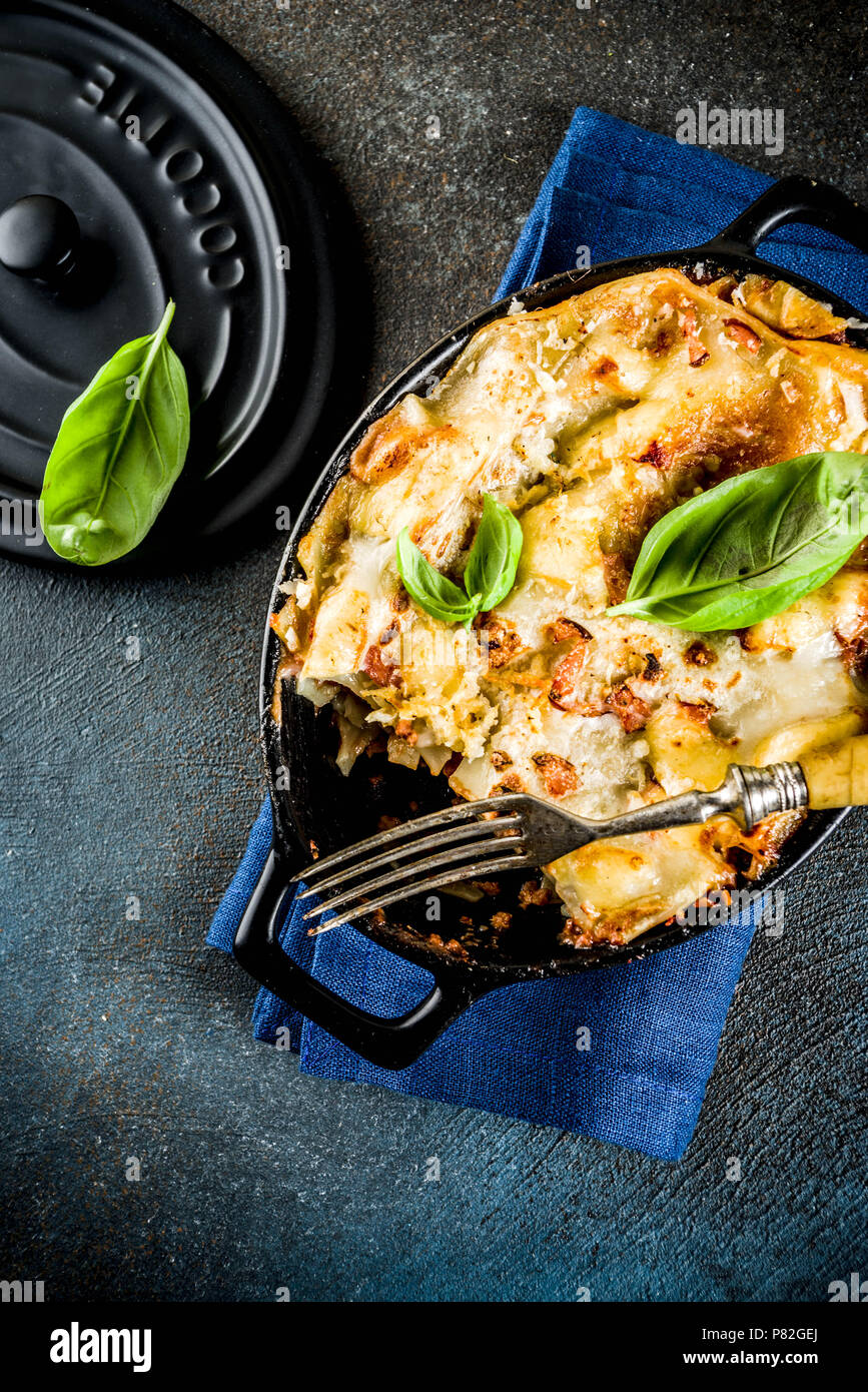Traditional italian food, homemade lasagna with fresh basil, dark blue