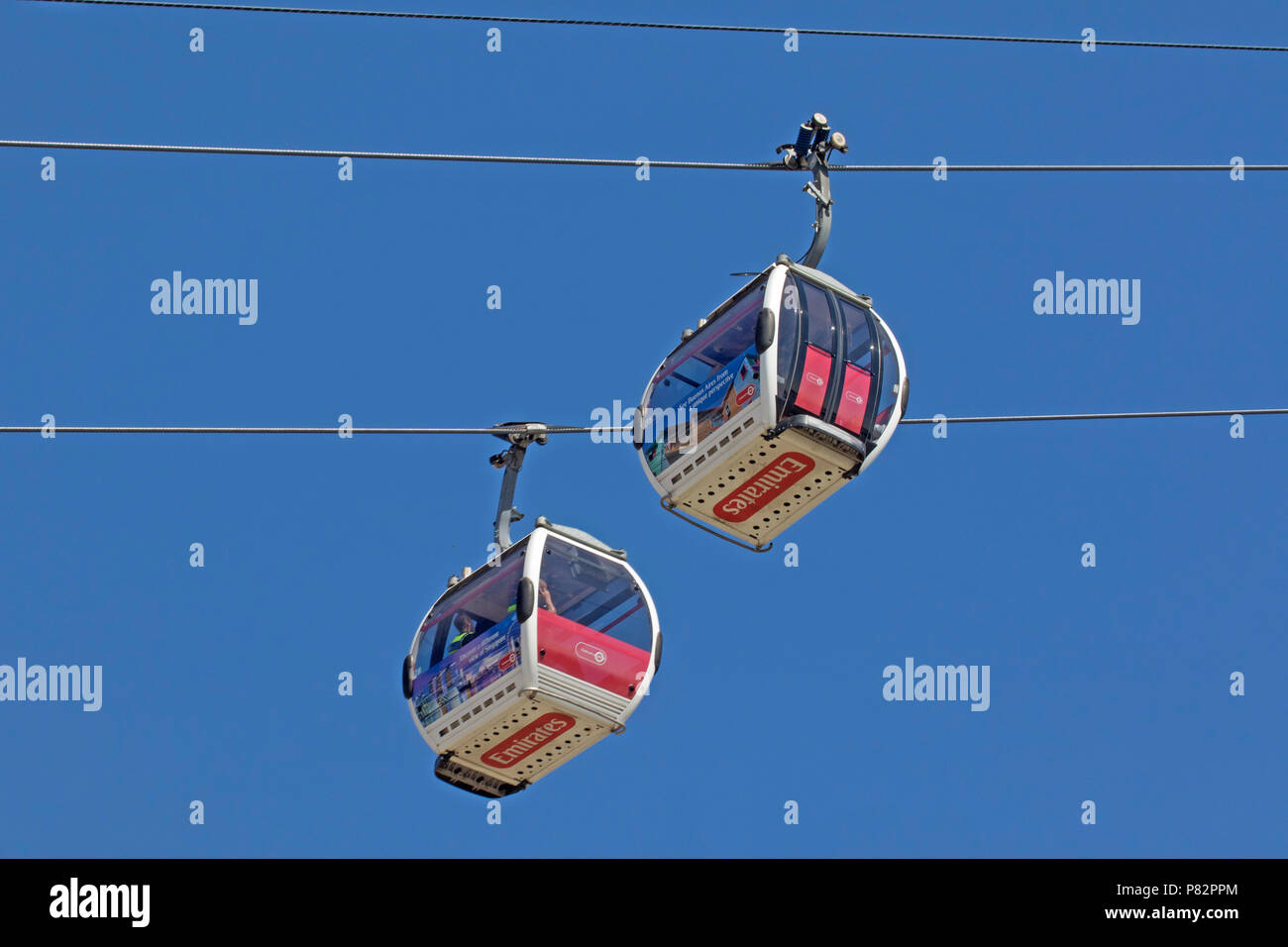London, North Greenwich  A pair of Emirates cable cars  or gondolas crossing Stock Photo
