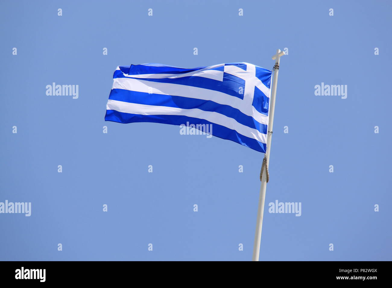 Greek national flag fluttering in the wind above the Presidential Mansion and current Greek Parliament Building in Athens, GREECE, PETER GRANT Stock Photo