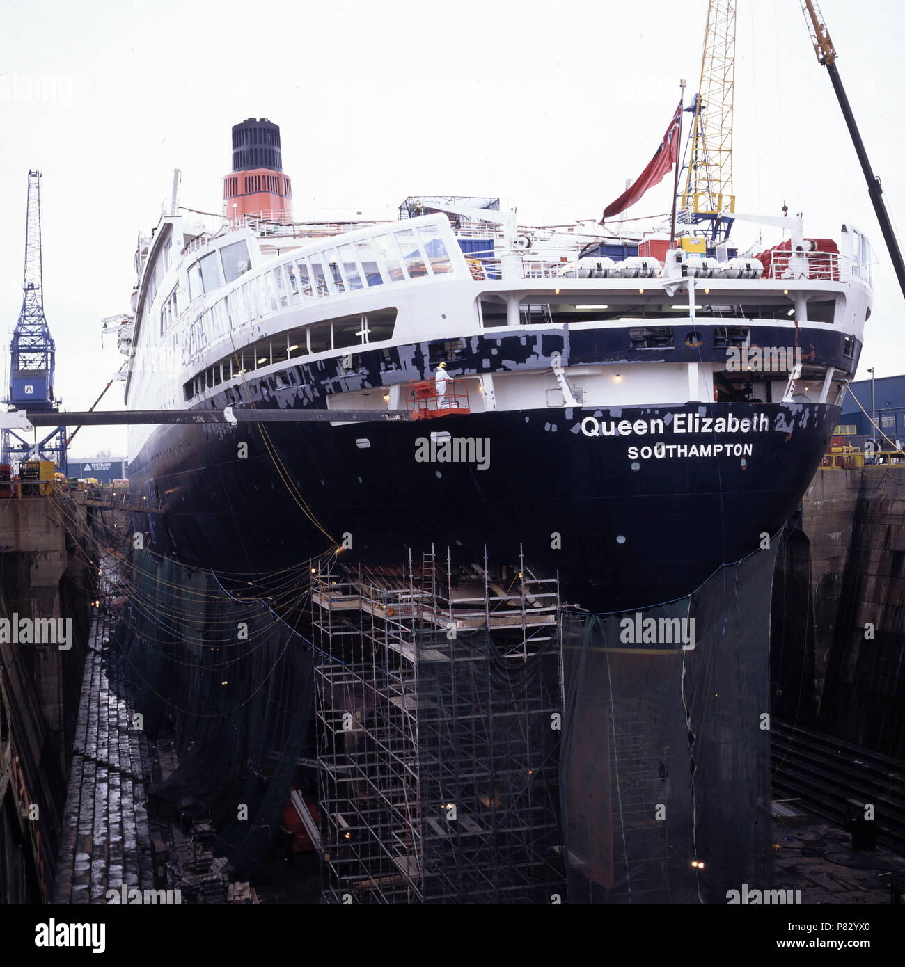 AJAXNETPHOTO. DEC 1996. SOUTHAMPTON, ENGLAND. -  PORT QUARTER VIEW OF THE CUNARD PASSENGER LINER QUEEN ELIZABETH 2 - QE2 - IN KGV DRY DOCK, HER HULL SHROUDED IN NETTING, UNDERGOES REFIT.  PHOTO:JONATHAN EASTLAND/AJAX.  REF:1296 34 Stock Photo