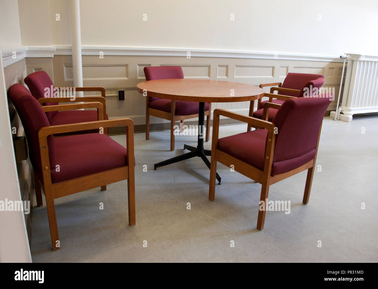 Five empty chairs around a table in a school or office workspace Stock Photo