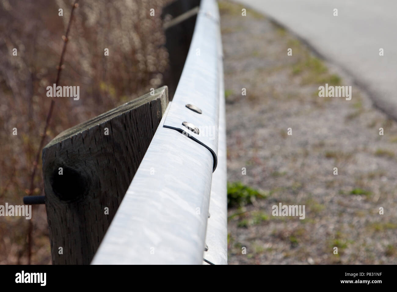 Bolted together, a guard rail made of metal is a barrier between the road and danger Stock Photo