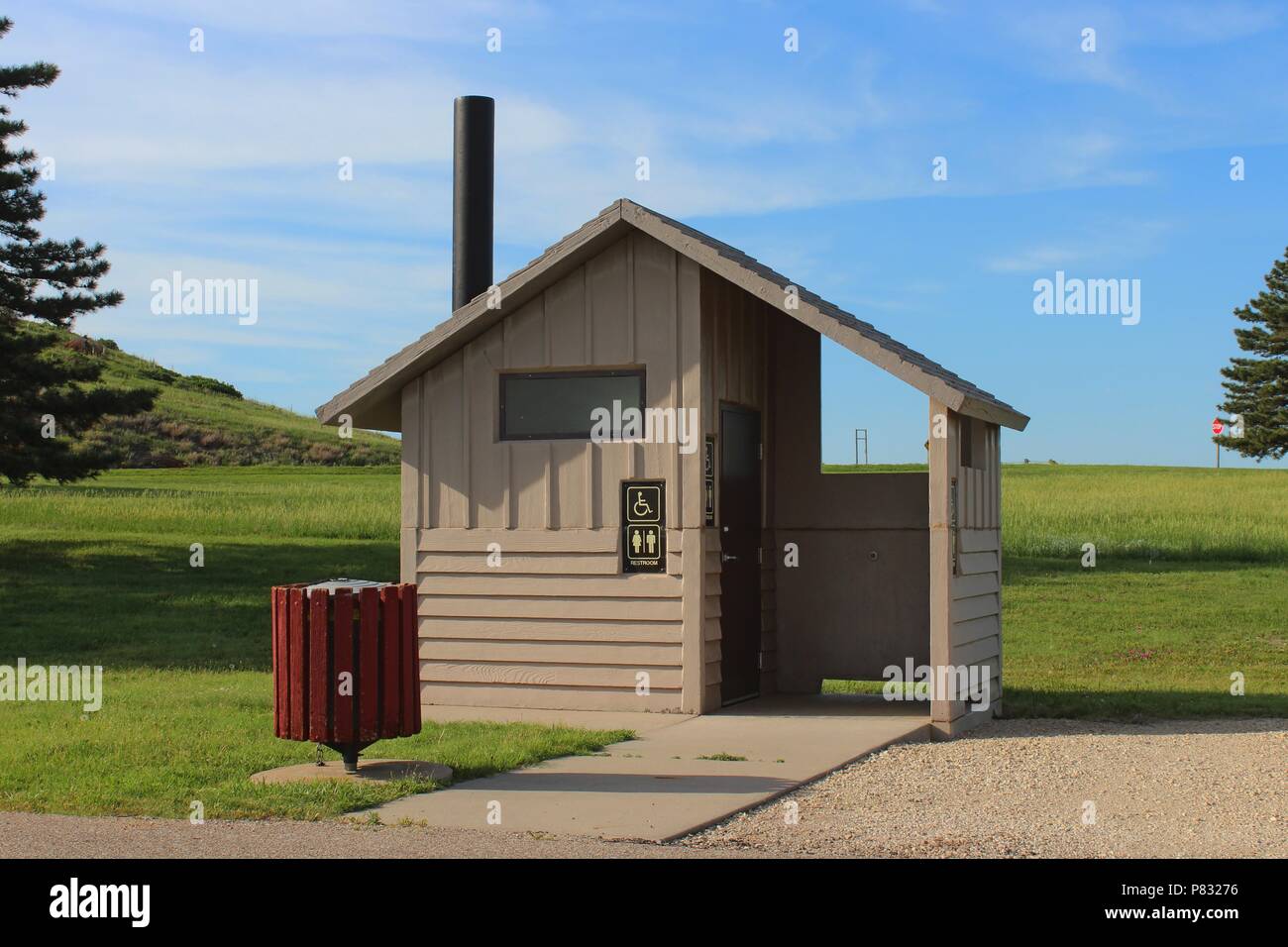 An Out House at Wilson Lake south of Lucas Kansas USA with green grass,blue sky and white cloud's. That's by the Dam. Stock Photo