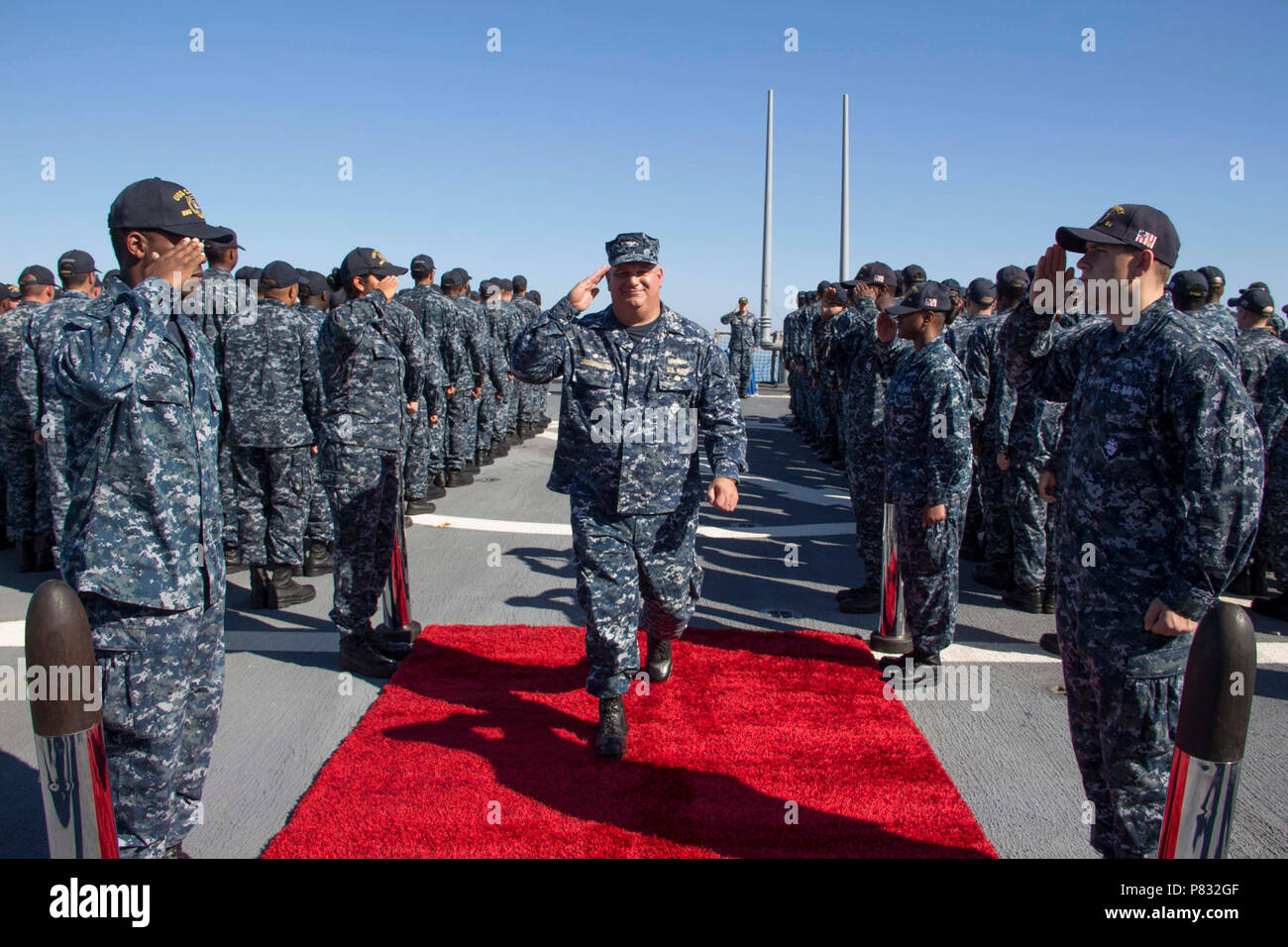 SEA (Nov 5, 2016) - Side boys render honors to Capt. Rich Dromerhauser, commodore, Destroyer Squadron 60, as he departs a change of command ceremony aboard USS Carney (DDG 64) Nov. 5, 2016. Carney, an Arleigh Burke-class guided-missile destroyer, forward-deployed to Rota, Spain, is conducting a routine patrol in the U.S. 6th fleet area of operations in support of U.S. national security interests in Europe. Stock Photo