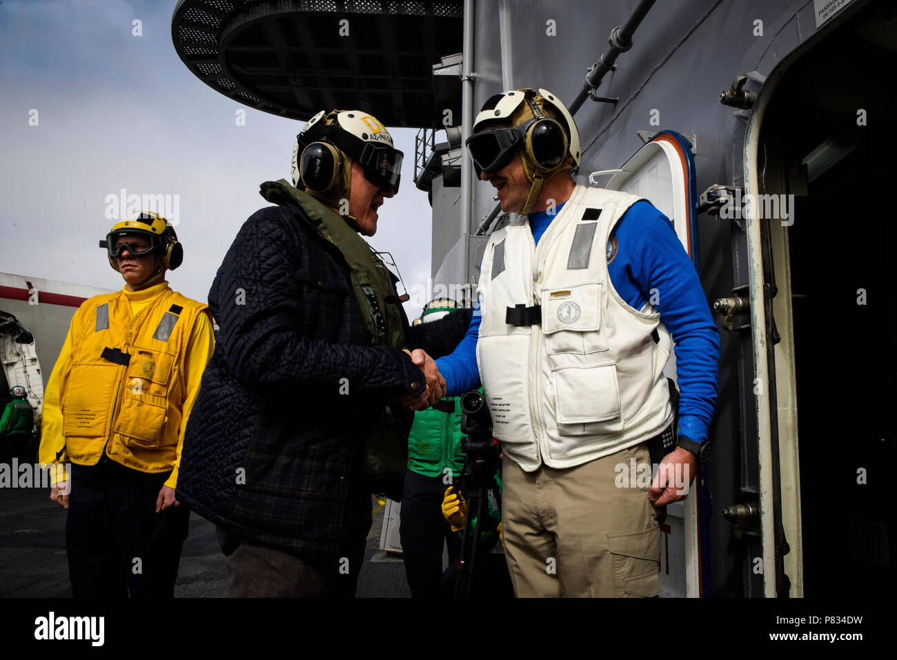 PACIFIC OCEAN (Feb. 10, 2017) Capt. Craig Clapperton, commanding officer of the aircraft carrier USS Theodore Roosevelt (CVN 71), greets former Secretary of the Navy John Lehman. Theodore Roosevelt is off the coast of Southern California conducting routine training operations. Stock Photo