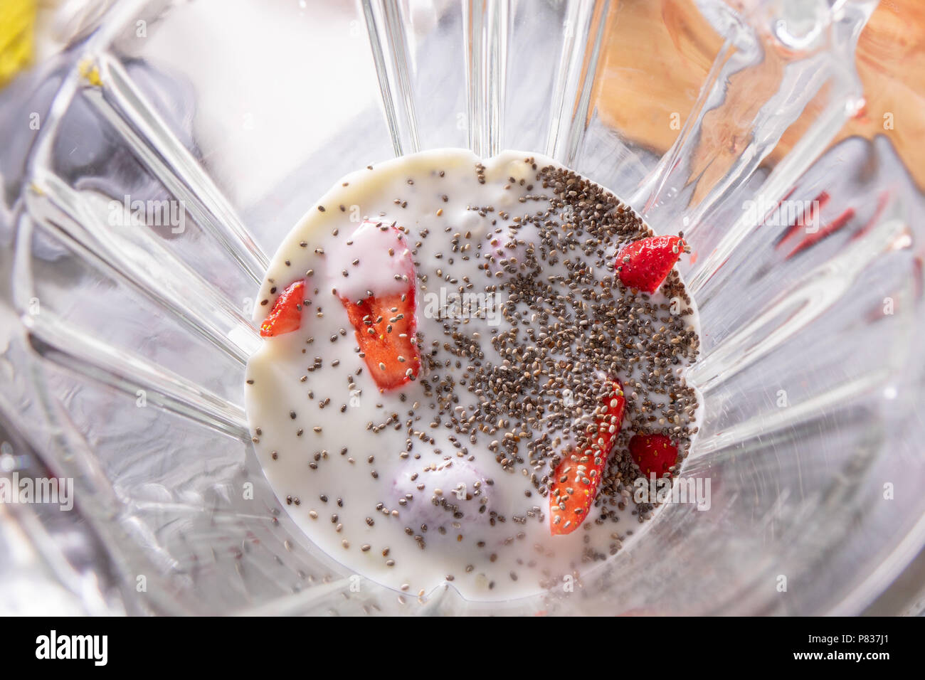 Pink smoothie in a blender with strawberries and chia seeds, view from