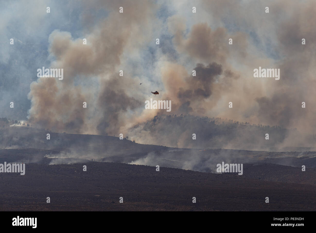 Alabama Hills, Lone Pine, CA. July 8, 2018. A  Sikorsky S-61 helicopter above the Georges Fire in the Alabama Hills west of Lone Pine, CA in eastern Sierra Nevadas.  The cause is under investigation. Lightning had been observed in the area. Fire crews from Inyo National Forest, the Bureau of Land Management (BLM),  CALFIRE, and local fire departments are fighting the fire with assistance from air tankers and helicopters. The helicopters are drawing water from the nearby California aquaduct. Credit: Ironstring/Alamy Live News Stock Photo