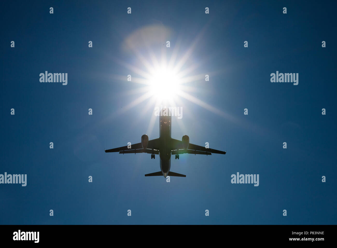 Silhouette of passenger airplane against bright sun Stock Photo