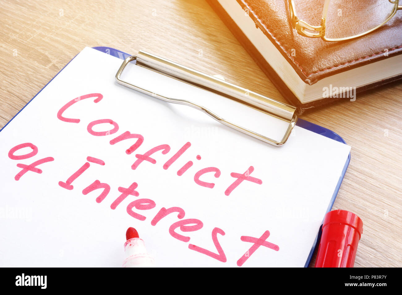 Conflict of interest written on a piece of paper. Stock Photo