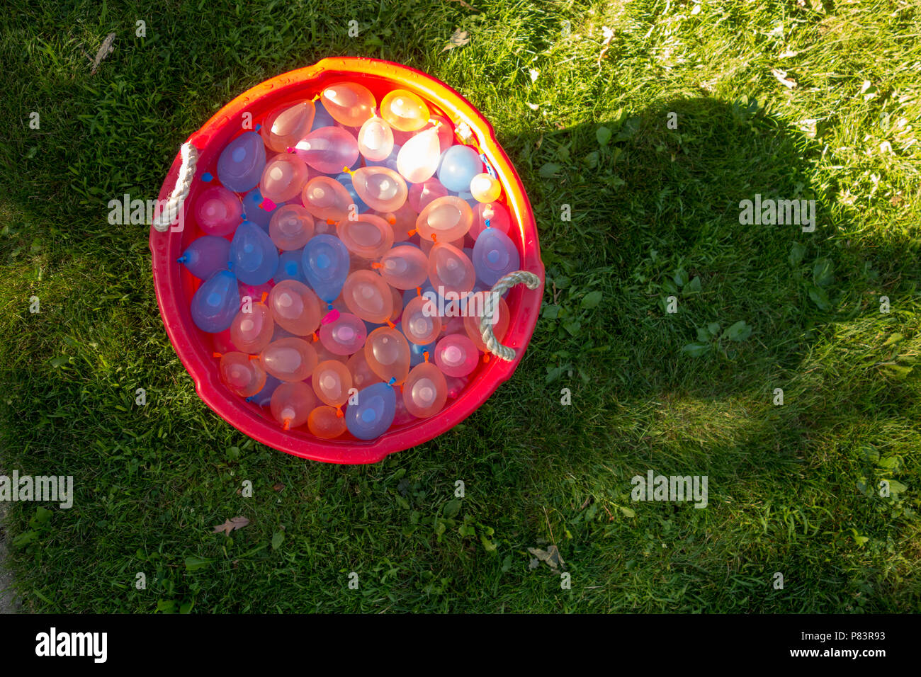 A tub full of water balloons ready for summer fun Stock Photo