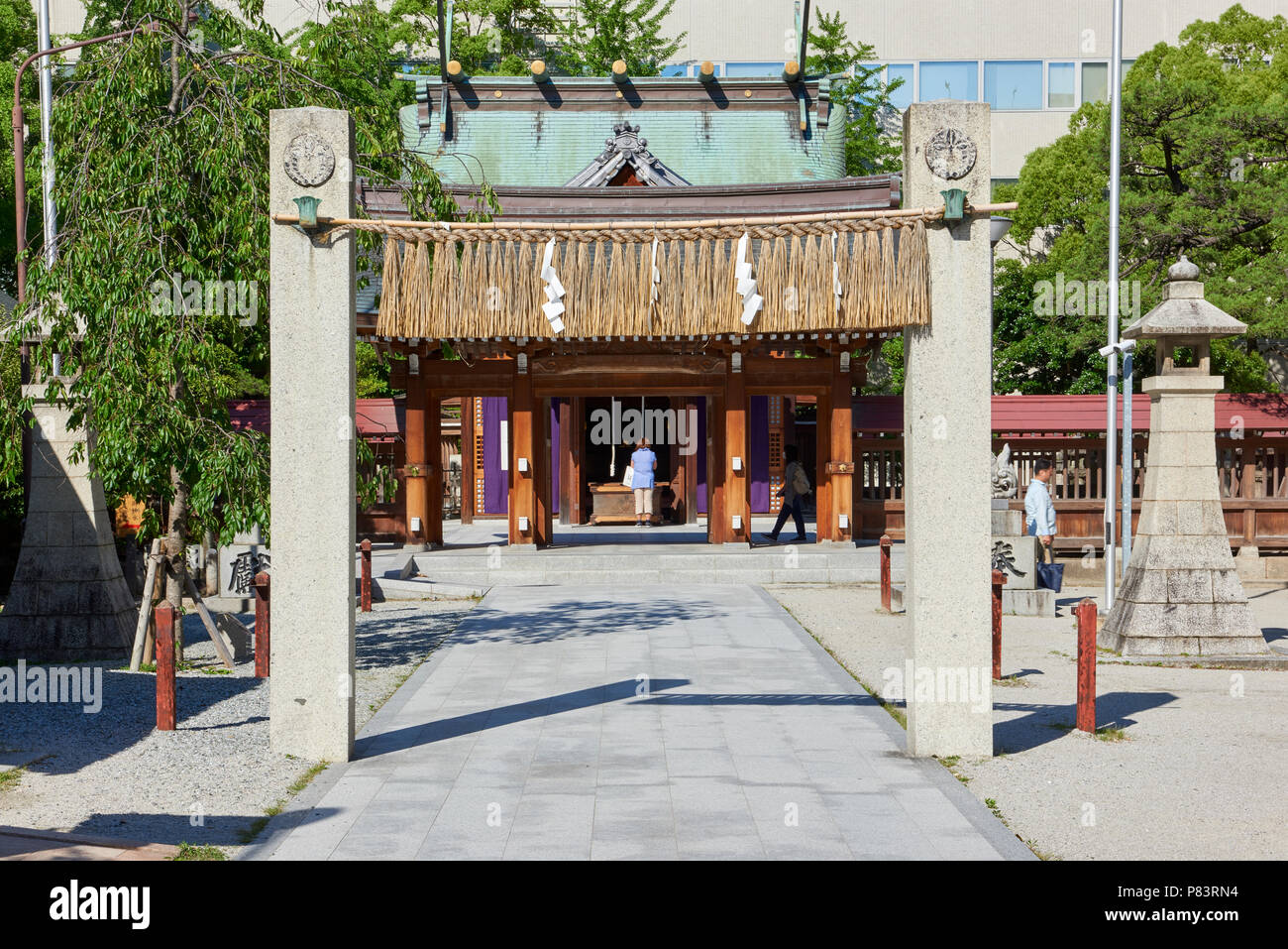 Torii stone gates in Kego Shrine  n Tenjin, central Fukuoka, Japan. The shrine is surrounded by busy streets and modern buildings. Stock Photo
