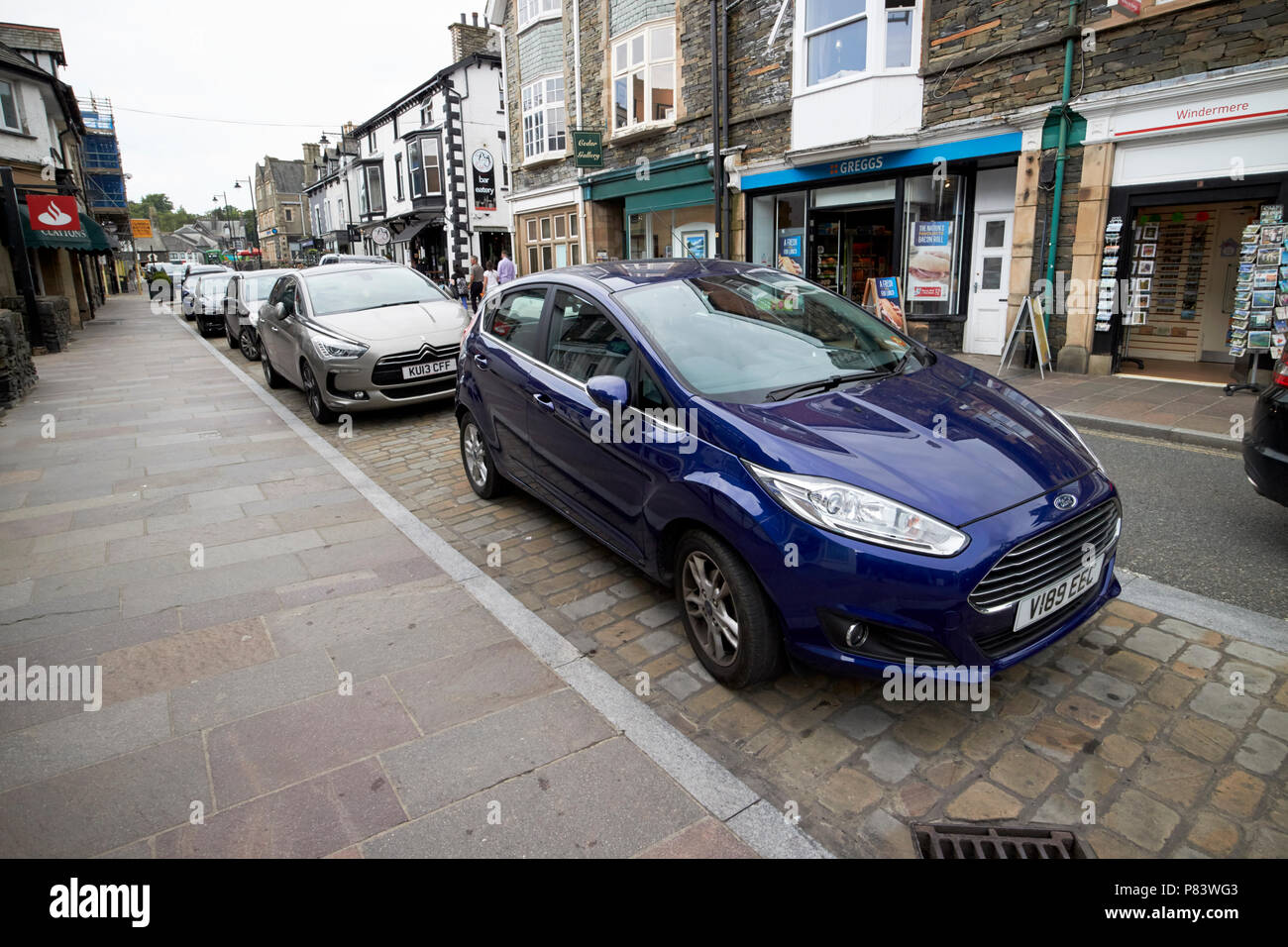 cars parked in layby onstreet parking on crescent road in windermere lake district cumbria england uk Stock Photo