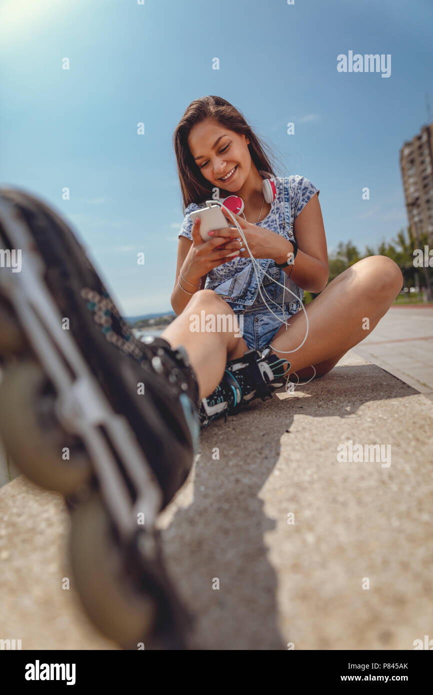 Cute smiling young Filipino woman surfing on or typing message