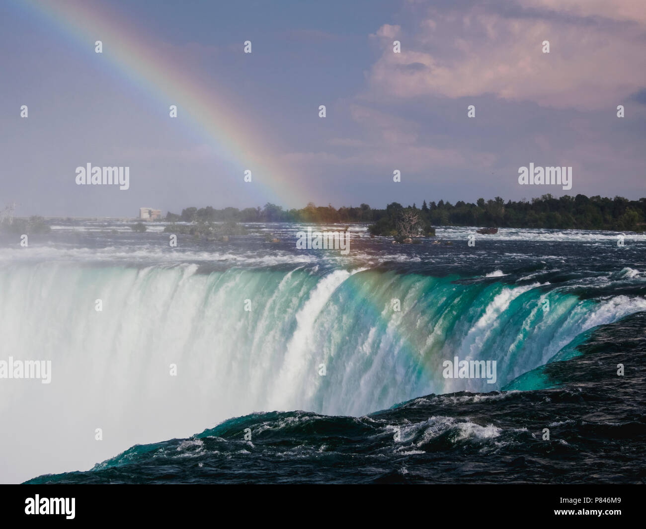 A wide angle shot of Horseshoe Falls, Niagara Falls, Ontario, Canada on a sunny day with full rainbow Stock Photo