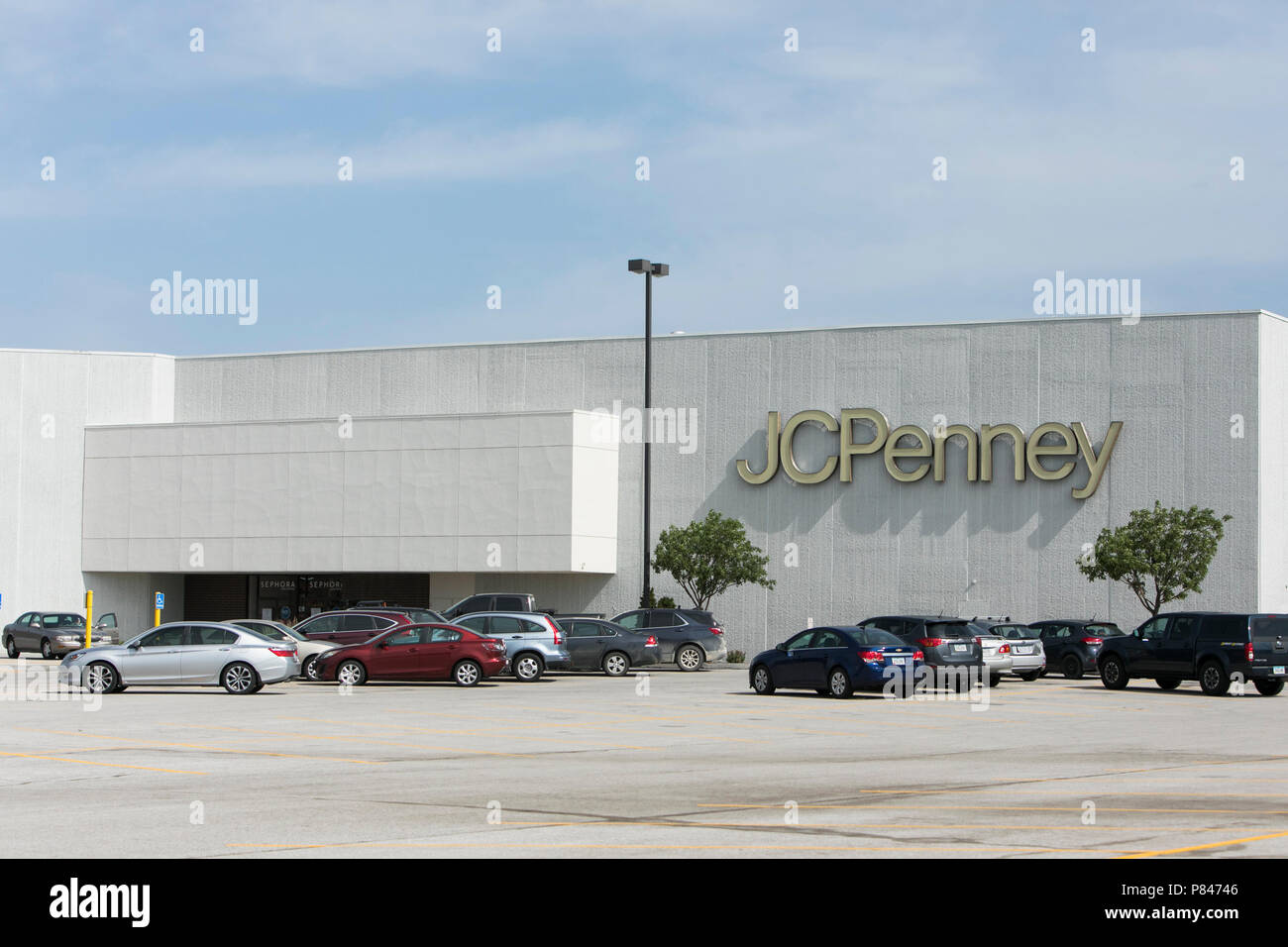 A logo sign outside of a JCPenney retail department store in West Des