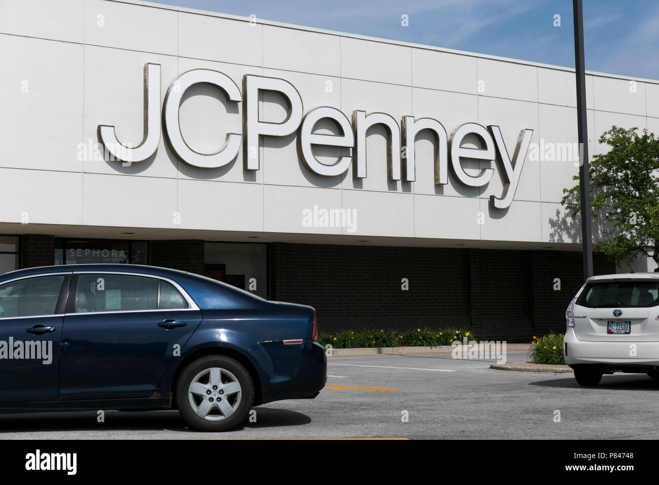 A logo sign outside of a JCPenney retail department store in West Des
