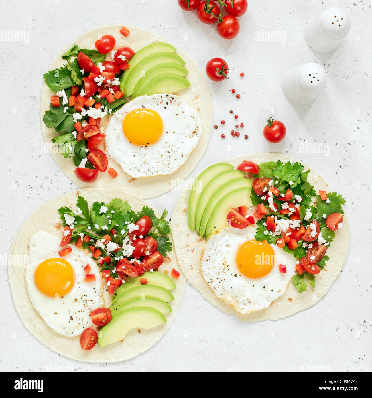 Breakfast tortilla taco with egg, avocado, salsa on bright background, top view, square crop Stock Photo