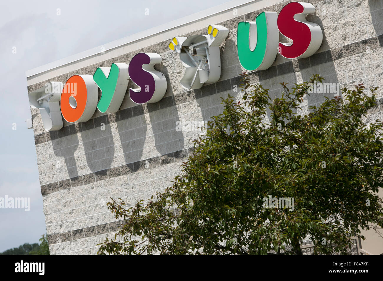 A logo sign outside of a now closed Toys-R-Us retail store in Des Moines, Iowa, on June 30, 2018. Stock Photo