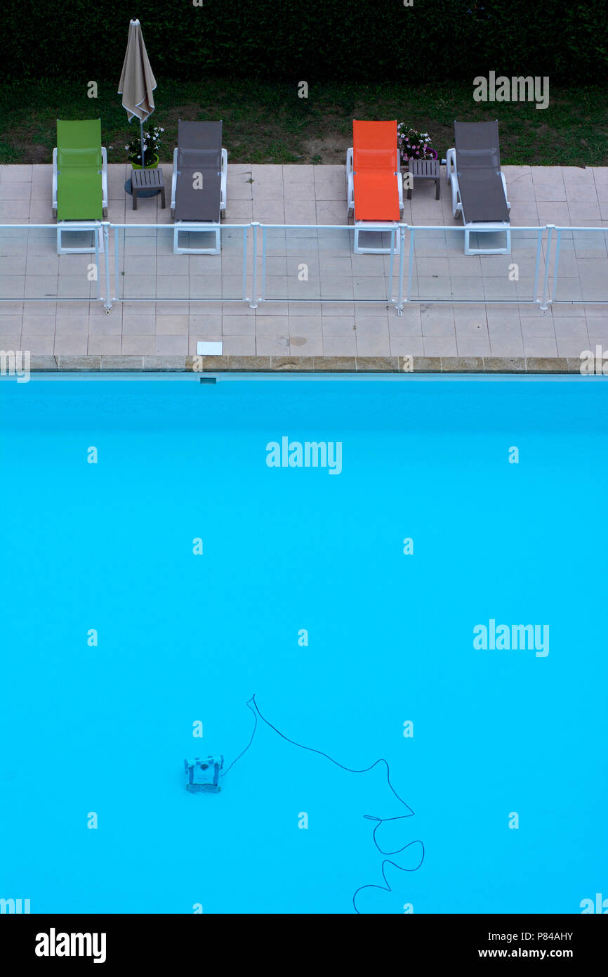 Cleaning Robot In A Swimming Pool And Deck Chairs On The