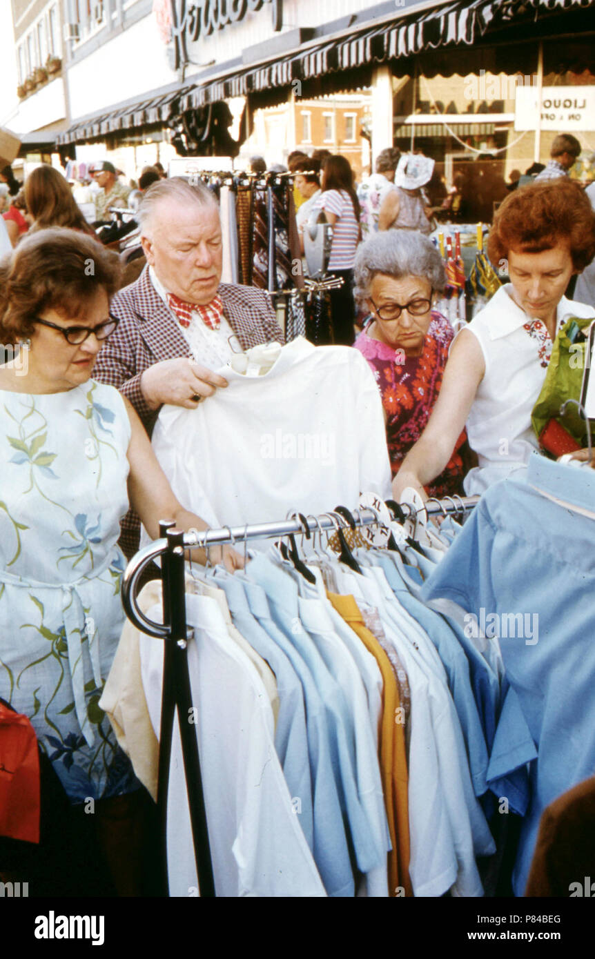 Adults Looking over Bargain Merchandise Placed in the Street on the Sidewalks by Merchants in New Ulm, Minnesota, During Their Annual Summer Crazy Days Sale. 1975 Stock Photo