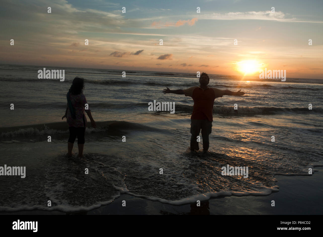 A couple roams at the Teknaf Sea Beach. It is a part of the Cox's Bazaar Sea Beach, the longest sea beach in the world. Teknaf, Cox´s Bazar, Banglades Stock Photo