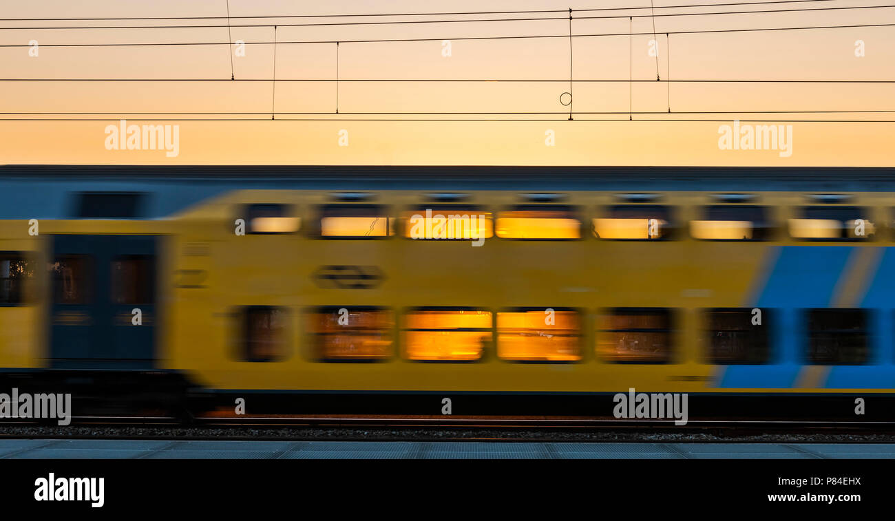 Amersfoort, The Netherlands - June 28, 2018: train of the NS passing by at Amersfoort with the sunset behind the train. Stock Photo