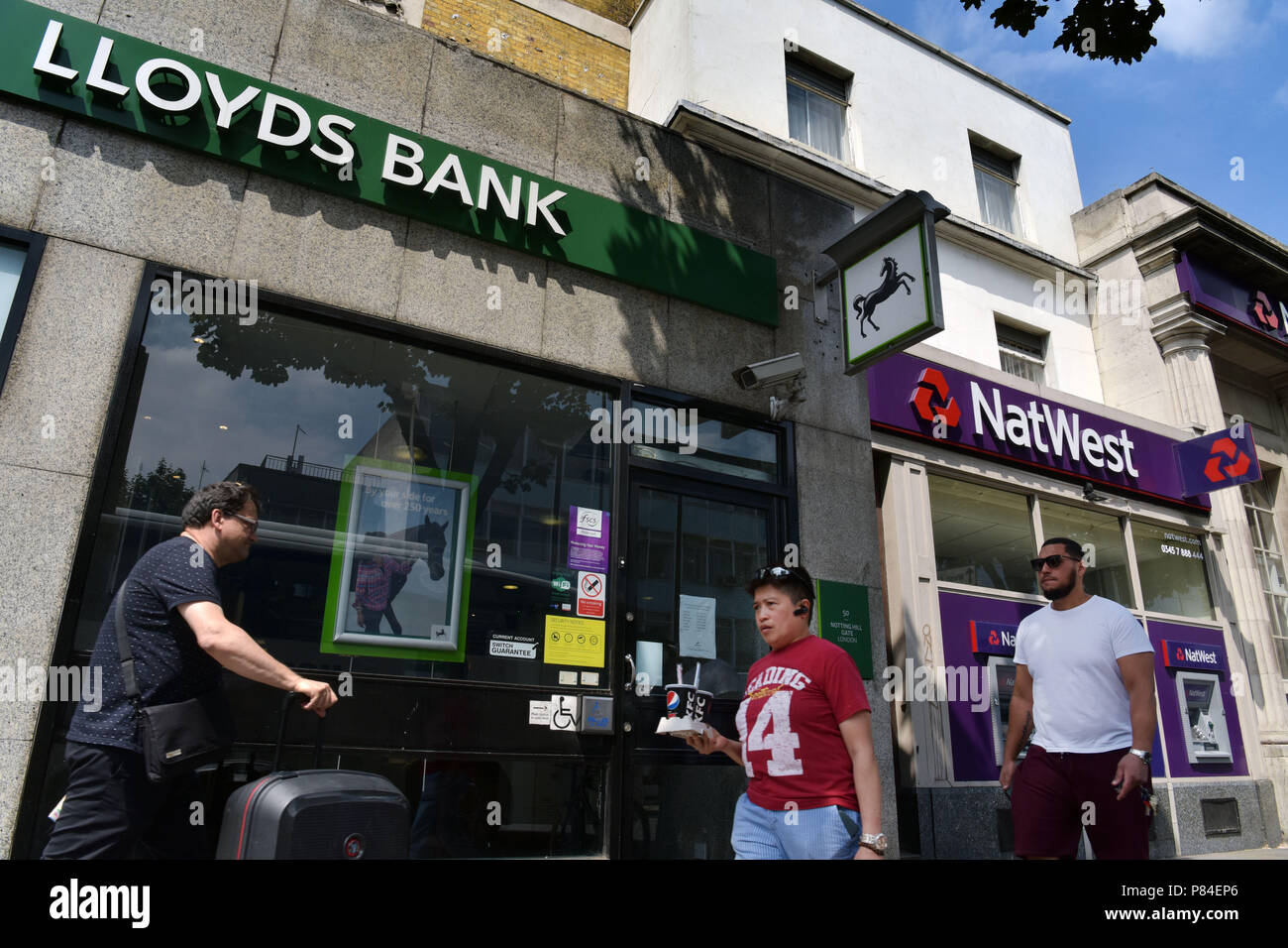 People walk past the branches of NatWest and Lloyds banks in Notting Hill London Stock Photo