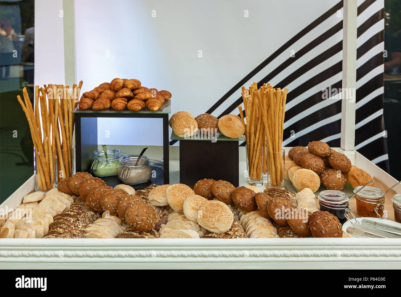 Bread assortment at the event croissants, buns with seeds and breadsticks jams and putty Stock